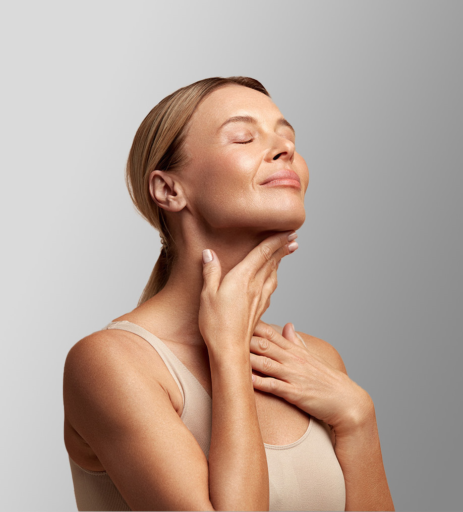 Photo of a woman with great skin touching her neckline